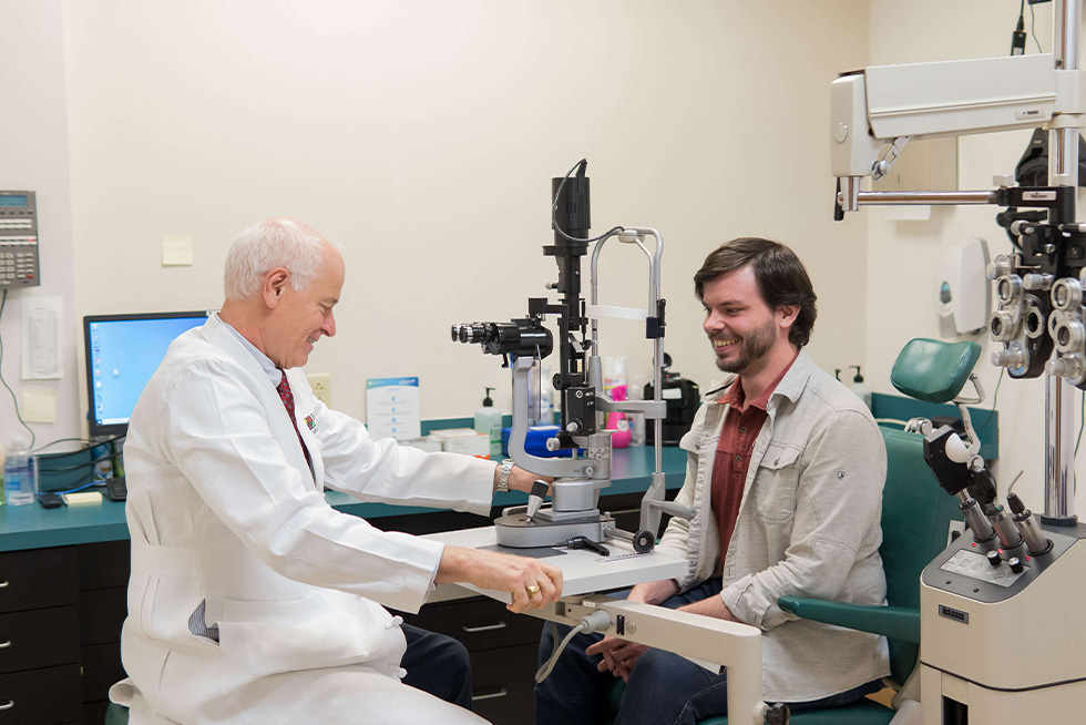 dr baker and a patient laugh together during an eye exam