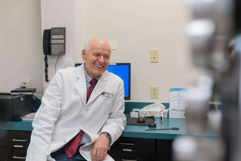 dr baker smiles at a patient out of frame in an exam room