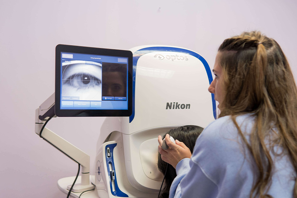 a nurse helps a patient get adjusted to take an optical photo