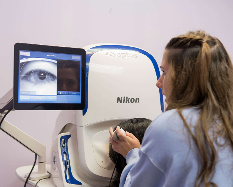 a nurse helps a patient get adjusted to take an optical photo