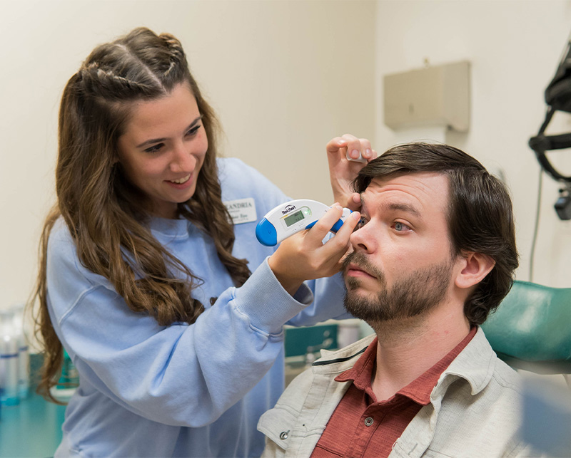 nurse tests patient's eye pressure with a tool