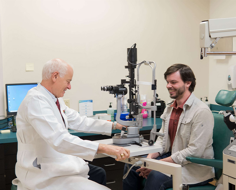 dr baker talks to a patient in between the eye exam procedures